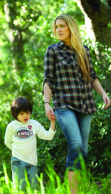 An adult and child walking beneath trees, from the OC Parks brochure