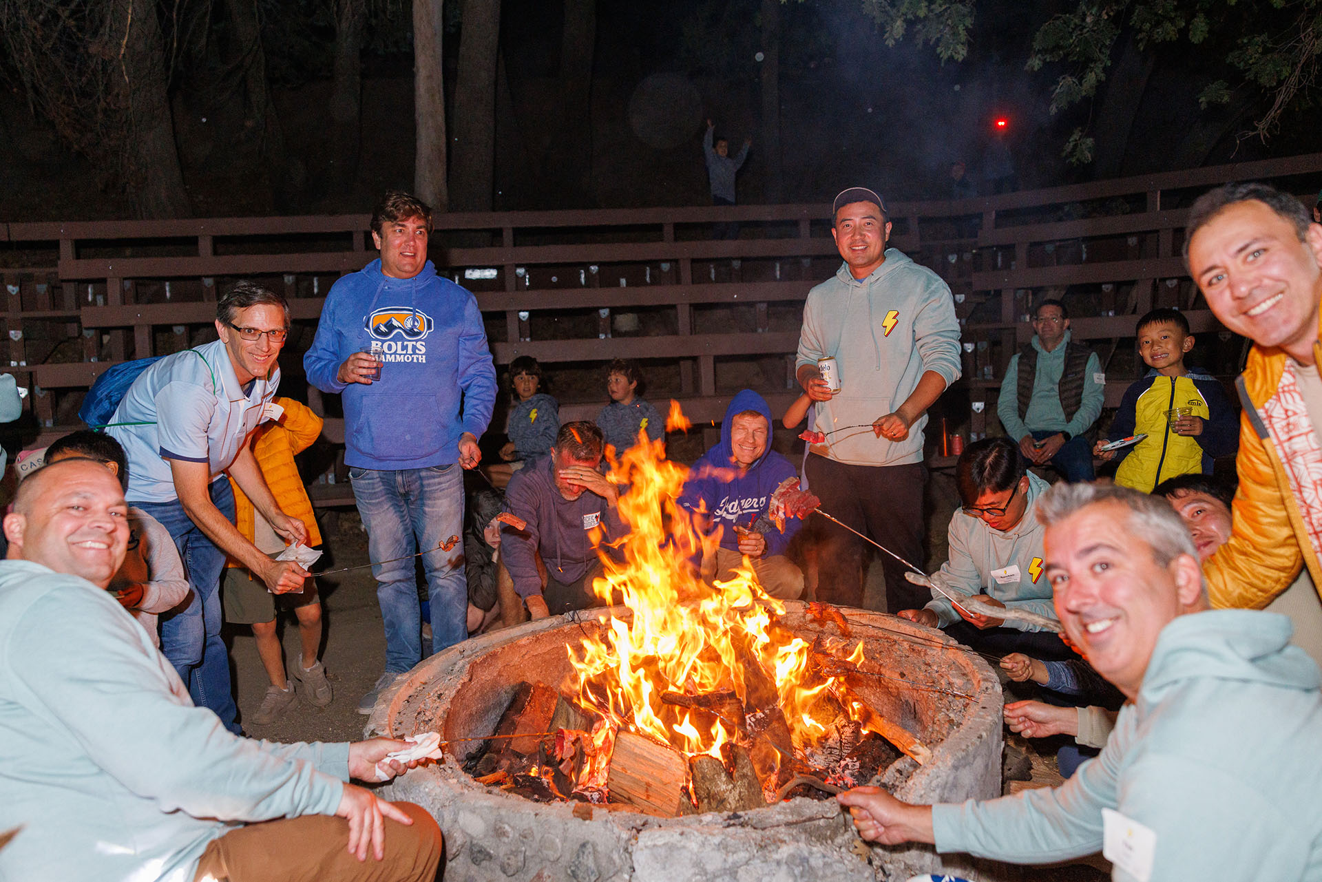 Dads and boys gathered around a glowing campfire during the Pali weekend